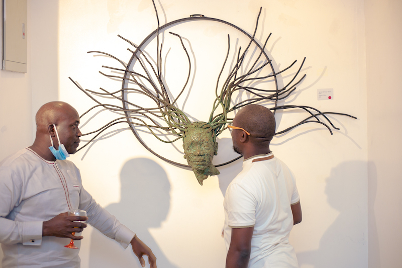 Curator Ovie Omatsola explains the sculpture to Executive Director, VFD Group, Gbenga Omolokun.